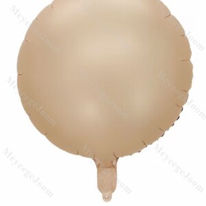 Puede incluir: Un globo redondo de color marr&oacute;n claro con un brillo met&aacute;lico. El globo est&aacute; desinflado y tiene una peque&ntilde;a abertura en la parte inferior.