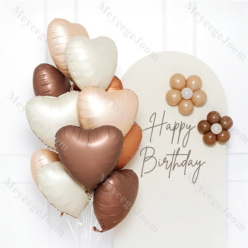 Puede incluir: Un ramo de globos en forma de coraz&oacute;n en tonos marrones, beige y blanco. Los globos est&aacute;n dispuestos en un racimo y tienen un acabado brillante. Los globos est&aacute;n decorados con las palabras "Happy Birthday".