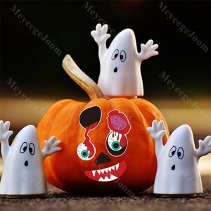 Op de afbeelding: Een oranje pompoen versierd met Halloween-stickers, waaronder een gezicht met druipende ogen en een rode mond. Drie witte spookfiguren met uitgestrekte armen omringen de pompoen, wat een griezelige scène creëert.