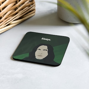May include: Square coaster with a dark green background featuring a stylized illustration of a person with long black hair. The word "Always" is printed in white at the top. The coaster is a decorative item.