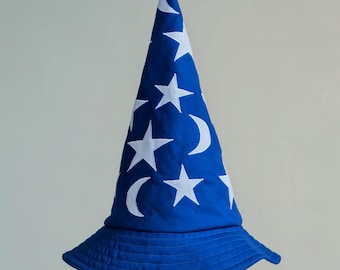 May include: A blue wizard hat with white stars and crescent moons. The hat is on a white pedestal.