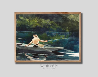 May include: A framed watercolor painting depicts a person in a boat fishing on a lake. The person wears a hat and light-colored clothing. The water reflects the sky and the green trees on the far shore. The frame is a light brown color.