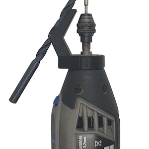 Peut inclure: Un outil rotatif gris et noir avec un bouton bleu et un foret noir fixé à la pince. L'outil porte une étiquette indiquant "EL 4000 F013400046, 1mm MAX. Ø 3,2mm, 100/min, CE, 04/2017, 704".