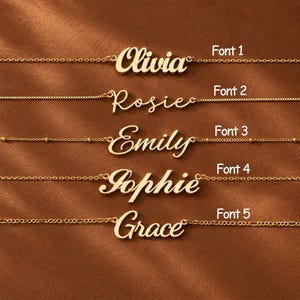 Könnte beinhalten: Fünf goldfarbene Namensketten, horizontal angeordnet, jede mit einer anderen Schreibschrift. Die Namen lauten Olivia, Rosie, Emily, Sophie und Grace, beschriftet mit Font 1 bis Font 5, mit jeweils unterschiedlichen Kettenarten für jedes Stück.