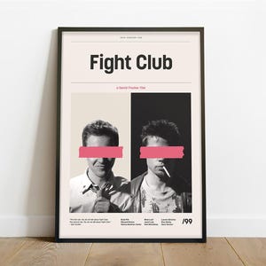 May include: A black and white poster with the title "Fight Club" in bold white text. The poster features two men, each with a pink stripe covering their eyes. The text "A David Fincher Film" is below the title. The poster has the year "'99" in the bottom right corner.