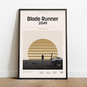 May include: A black framed poster with a minimalist design featuring the title "Blade Runner 2049" in bold black text. The poster has a beige background with a stylized gold sun and a silhouette of a person walking towards a futuristic vehicle.