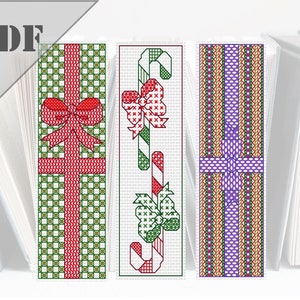 May include: Three Christmas-themed cross-stitch bookmark patterns. The first pattern features a red gift box with a green bow. The second pattern features a candy cane with a green bow. The third pattern features a purple gift box with a green bow.