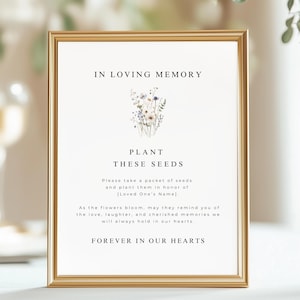 May include: A gold-framed sign with the text "IN LOVING MEMORY" and "PLANT THESE SEEDS." The sign features a floral illustration and the words "FOREVER IN OUR HEARTS."