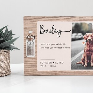 May include: A wooden memorial frame with a photo of a brown dog and a small glass jar with a cork lid. The frame has the text "Bailey", "I loved you your whole life, I will miss you the rest of mine." and "FOREVER LOVED 2010 - 2024".