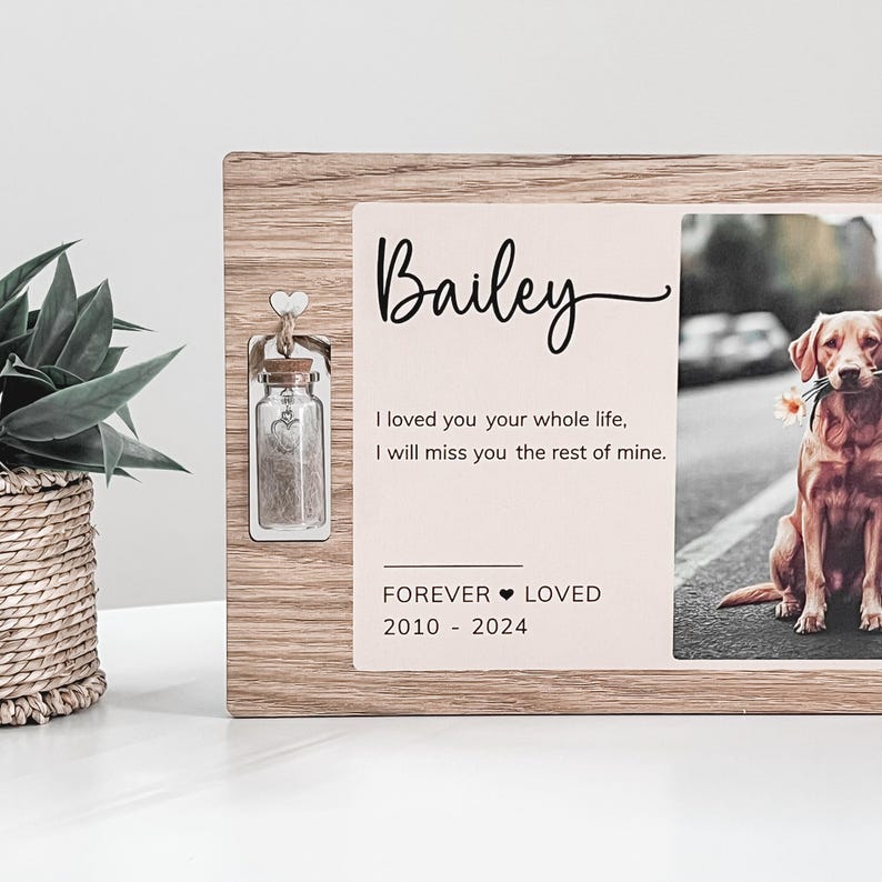 May include: A wooden memorial frame with a photo of a brown dog and a small glass jar with a cork lid. The frame has the text "Bailey", "I loved you your whole life, I will miss you the rest of mine." and "FOREVER LOVED 2010 - 2024".