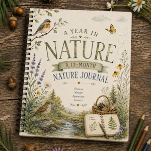 以下が含まれることがあります： スパイラル綴じのネイチャージャーナル。表紙には「A Year in Nature, A 12-Month Nature Journal」のタイトル、青い鳥、蝶、小川、バスケット、シダの絵が描かれた開いた本が描かれています。テキストには「Observe, Wonder, Appreciate, Connect」と記されています。