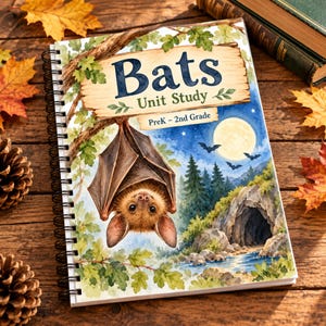 Op de afbeelding: Een spiraalgebonden educatief werkboek getiteld Bats Unit Study PreK - 2nd Grade. De kaft bevat een aquarelillustratie van een bruine vleermuis die aan een boomtak hangt, een volle maan, een bos, een grot en vliegende vleermuizen.