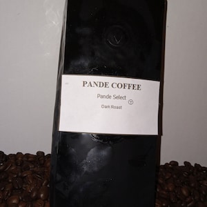 May include: A black bag of Pande Select Dark Roast coffee beans. The bag has a white label with the company name and roast type.