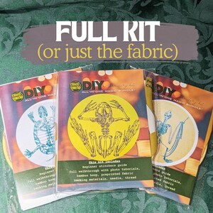 May include: Three DIY embroidery kits featuring skeleton designs. Each kit contains a beginner's guide, photo tutorials, a bamboo hoop, pre-printed fabric, backing materials, needle, and thread. The text "FULL KIT (or just the fabric)" is at the top.