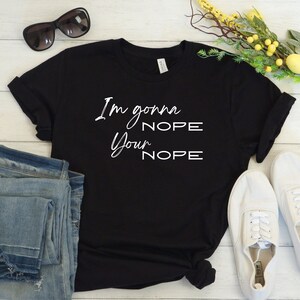 Peut inclure: T-shirt noir avec un texte blanc qui dit "I'm gonna NOPE your NOPE".