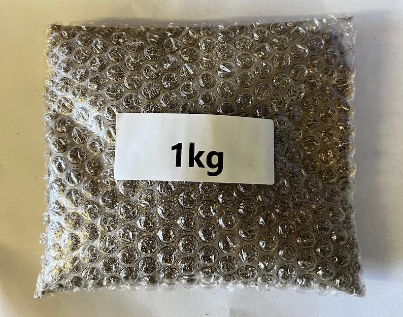 以下が含まれることがあります： 茶色の袋に「1kg」と書かれた白いラベルが付いており、茶色の物質で満たされています。袋は気泡緩衝材でできています。