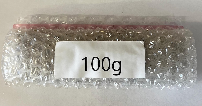 May include: A white bubble wrap package with a label that says "100g".