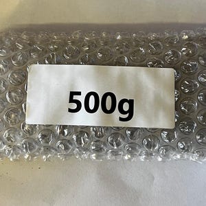 以下が含まれることがあります： グレーのプチプチ包装に「500g」と書かれた白いラベルが付いている。