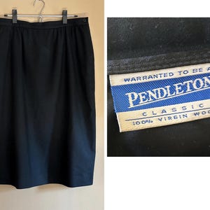 May include: A black skirt made of 100% virgin wool. The skirt is a classic style with a straight silhouette. The label reads "Pendleton Classic 100% Virgin Wool". The skirt is hanging on a hanger.