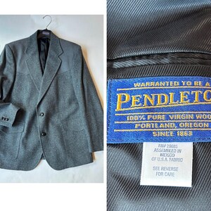 May include: A grey wool blazer with a western-style yoke, two black buttons, and two front pockets. The interior label reads: WARRANTED TO BE A PENDLETON 100% PURE VIRGIN WOOL PORTLAND, OREGON SINCE 1863, size 44, RN 29685 ASSEMBLED IN MEXICO OF U.S.A. FABRIC.