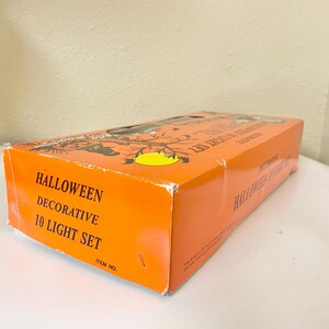 May include: Orange Halloween decorative 10 light set box. The box has black silhouettes of bats and a yellow moon. The text "Halloween Decorative 10 Light Set" is printed on the side of the box.
