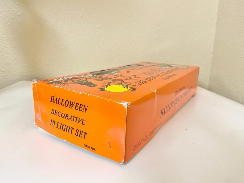 May include: Orange Halloween decorative 10 light set box. The box has black silhouettes of bats and a yellow moon. The text "Halloween Decorative 10 Light Set" is printed on the side of the box.