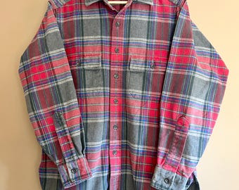 May include: A long-sleeved plaid shirt in red, gray, and blue, with a gray collar and cuffs. The shirt has two chest pockets and is button-down. The brand label is visible on the collar.