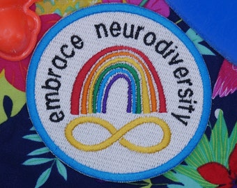 May include: A blue and white embroidered patch with a rainbow and infinity symbol. The text "embrace neurodiversity" is written around the edge of the patch.