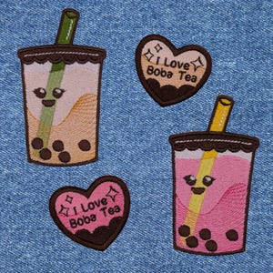 May include: Four embroidered patches featuring boba tea and hearts. Two patches are brown hearts with the text "I Love Boba Tea" in white. The other two patches are brown cups with a straw and boba pearls, one with a pink drink and the other with a yellow drink.
