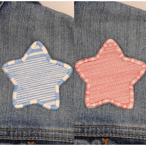 Könnte beinhalten: Zwei Jeansjacken mit gestickten Sternen. Ein Stern ist blau-weiß gestreift, der andere ist rosa mit weißem Rand.
