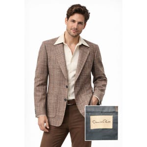 Puede incluir: Blazer marrón con tejido texturizado, con solapa de muesca y dos bolsillos delanteros. El blazer se combina con una camisa color crema y pantalones marrones. La etiqueta dentro del blazer dice "Oscar de la Renta".
