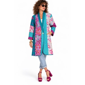 May include: A knee-length coat featuring a patchwork design with panels of teal, magenta, and floral patterns. The coat has long sleeves, a single front button closure, and a structured collar. It is paired with light blue denim jeans and magenta heels.