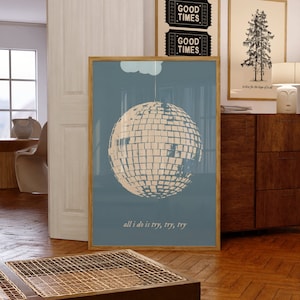 May include: A blue poster with a white disco ball hanging from a white cloud. The text "all i do is try, try, try" is at the bottom of the poster.