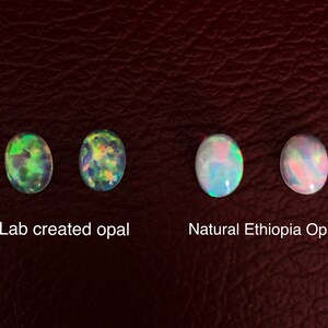 May include: Four oval-shaped opals, two lab-created and two natural Ethiopian opals. The lab-created opals have a green and blue iridescent sheen, while the natural opals have a more muted pink and blue sheen. The text "Lab created opal" and "Natural Ethiopia Opal" is printed below the opals.