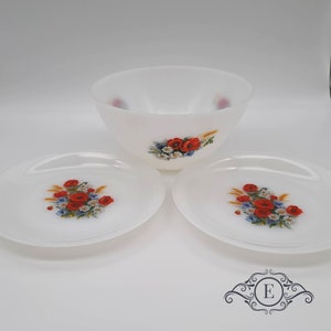 Peut inclure: Un ensemble de trois plats en céramique blanche avec un motif floral composé de coquelicots rouges, de fleurs sauvages bleues et blanches et d'épis de blé. L'ensemble comprend un bol et deux assiettes.