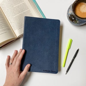 May include: A dark blue, soft-cover journal with the name "Luwanna Turn" written in black ink on the front cover.
