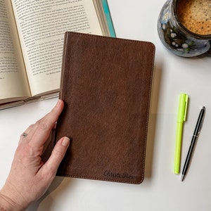 May include: A brown leather-bound journal with the name "Christi Brown" embossed in cursive on the front cover.