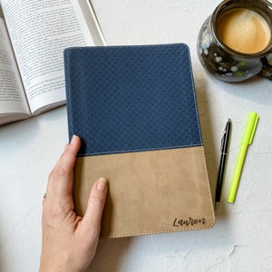 May include: A blue and brown leather-bound journal with the name "Lauren" embossed on the front cover.