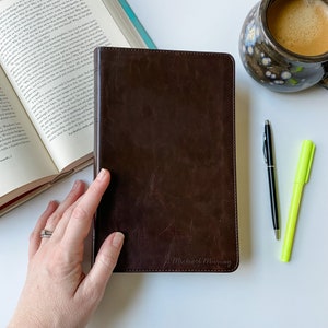 May include: A brown leather-bound journal with the name "Michael Murray" embossed on the front cover.