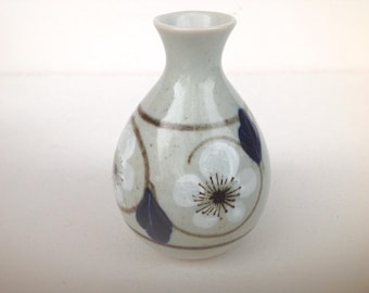 Jarrón vintage pintado a mano con flores blancas, azul y gris.