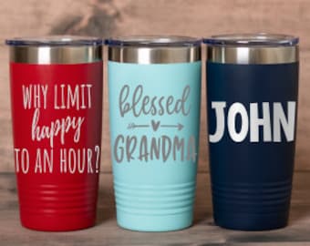 May include: Three stainless steel insulated tumblers with lids. One is red with the text "WHY LIMIT happy TO AN HOUR?", another is light blue with "blessed GRANDMA", and the third is navy blue with the name "JOHN".