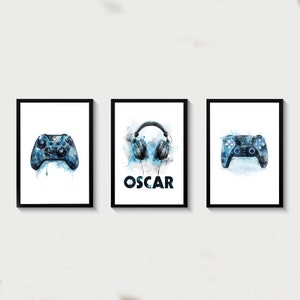 May include: Three framed prints with a watercolor design. The center print features a pair of blue headphones with the name "OSCAR" below. The left print features a blue video game controller. The right print features a blue video game controller.