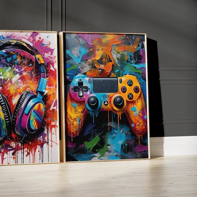 Pu&ograve; includere: Due stampe d'arte incorniciate con uno sfondo astratto colorato. La stampa a sinistra presenta un paio di cuffie con un design a spruzzo di vernice colorato. La stampa a destra presenta un controller per videogiochi colorato con un design a spruzzo di vernice.