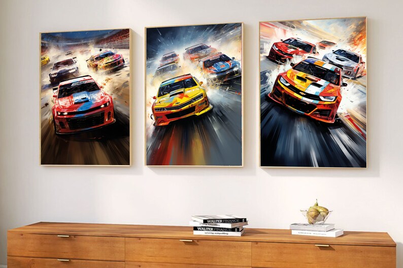 May include: Three framed paintings of colorful race cars speeding on a track. The cars are red, yellow, and blue with black accents. The paintings are set against a white wall with a wooden shelf below.