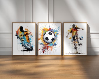 Pode incluir: Três impressões de arte emolduradas com um tema desportivo. A primeira impressão apresenta um close-up de uma chuteira de futebol preta e branca com respingos de tinta coloridos. A segunda impressão apresenta uma bola de futebol preta e branca com respingos de tinta coloridos. A terceira impressão apresenta um jogador de futebol com uma camisa amarela chutando uma bola de futebol com respingos de tinta coloridos.