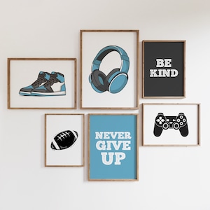 Puede incluir: Cinco impresiones enmarcadas con citas e imágenes motivacionales. Las impresiones están en un marco de madera claro y tienen un fondo blanco. Las impresiones incluyen un par de zapatillas azules y negras, un par de auriculares, un balón de fútbol, un mando de videojuegos y las palabras "Sé amable" y "Nunca te rindas".
