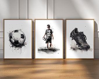 Puede incluir: Tres pinturas de acuarela enmarcadas que representan un balón de fútbol, un niño pequeño sosteniendo un balón de fútbol y una bota de fútbol negra. Las pinturas son en blanco y negro con salpicaduras de color.