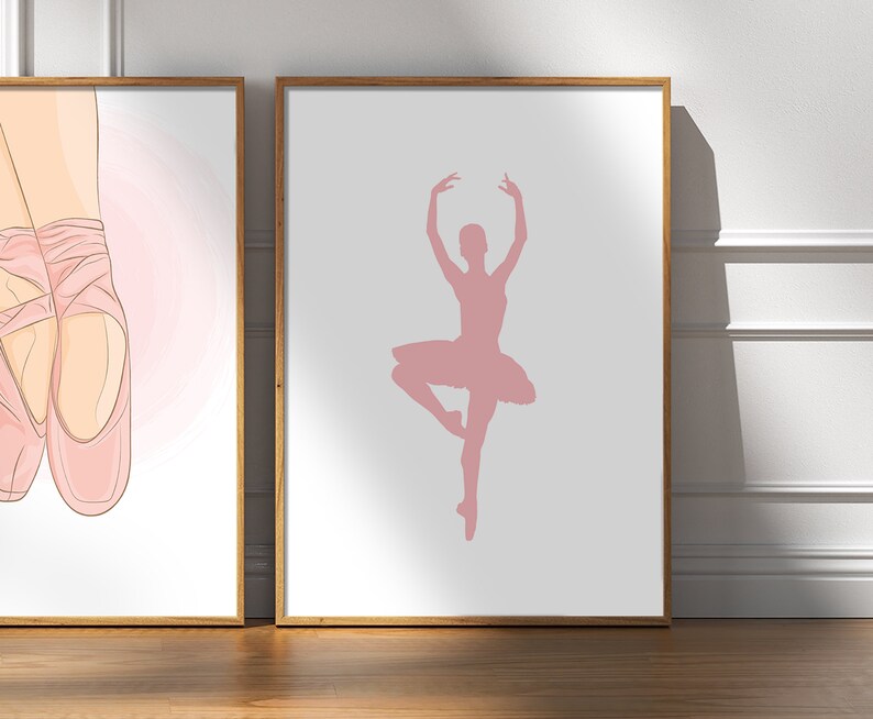 May include: Two framed art prints. One features a pair of pink ballet pointe shoes. The other print shows a pink silhouette of a ballerina in a graceful pose, wearing a tutu. Both prints have a white background and are in wooden frames.