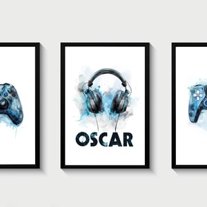 May include: Three framed prints with a blue watercolor background. The center print features a pair of black headphones with the name "OSCAR" in black text. The prints on either side feature a blue video game controller.