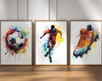 Pode incluir: Três aquarelas que retratam uma bola de futebol, um jogador de futebol e uma chuteira de futebol. As pinturas são emolduradas em madeira e têm um fundo branco com respingos de aquarela coloridos.